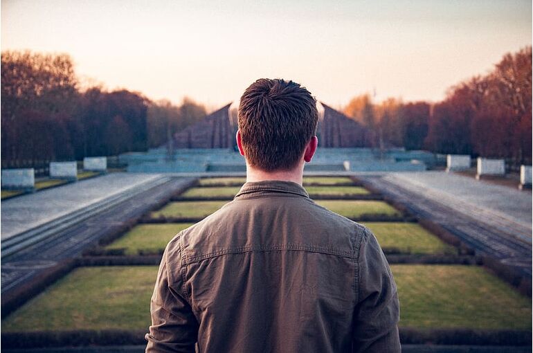 man-standing-between-pathway-during-daytime